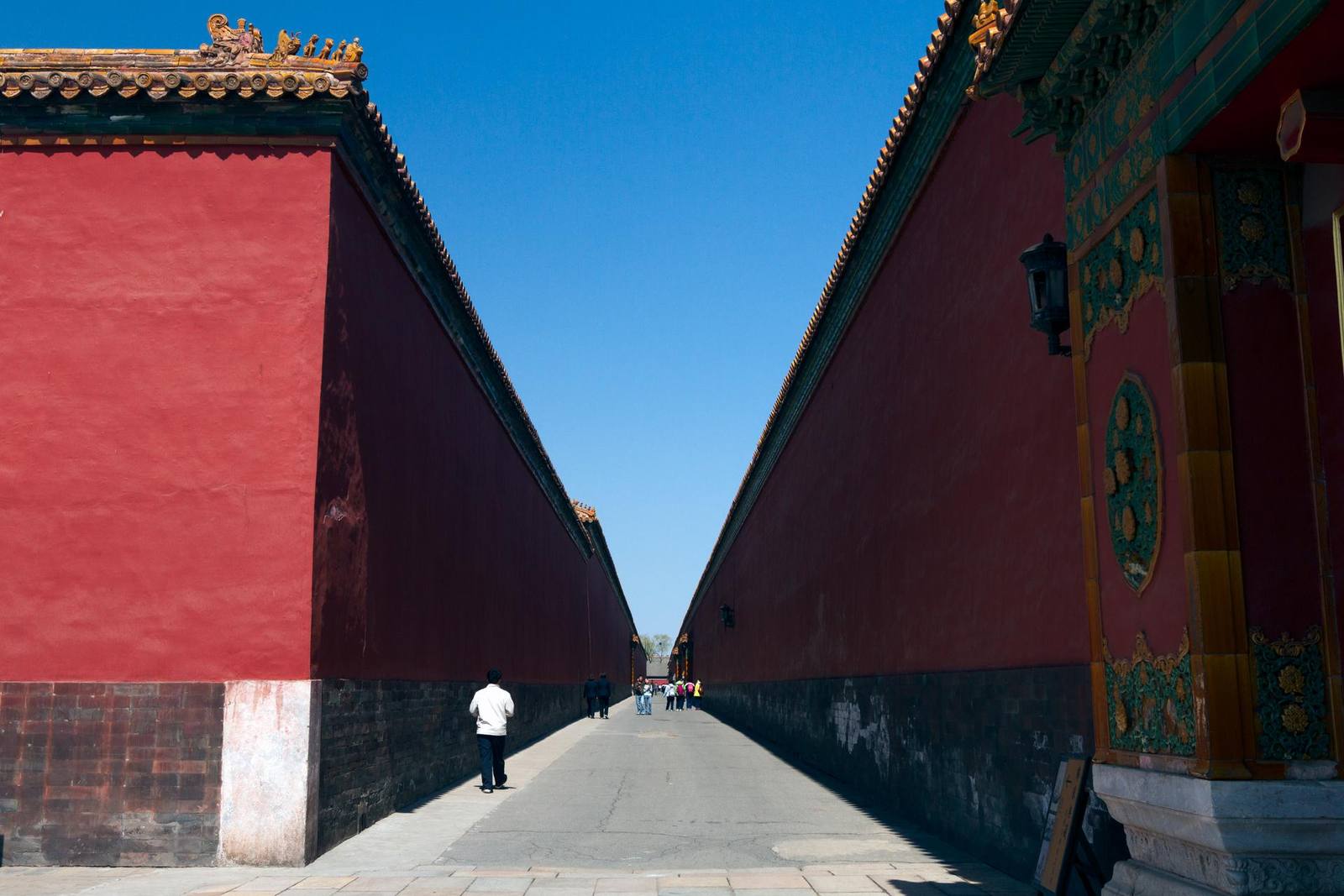 A deep lane between towering red walls inside the Forbidden City