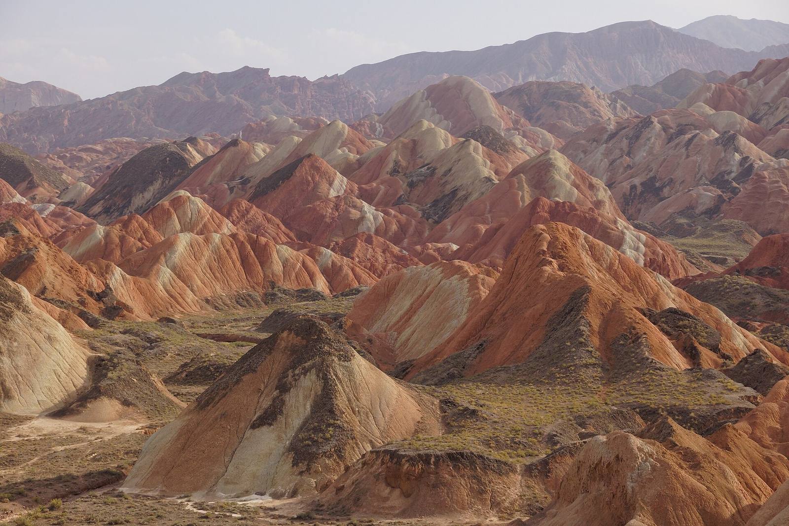 Layered ridges of red, ochre and cream rock in the Zhangye Danxia landform