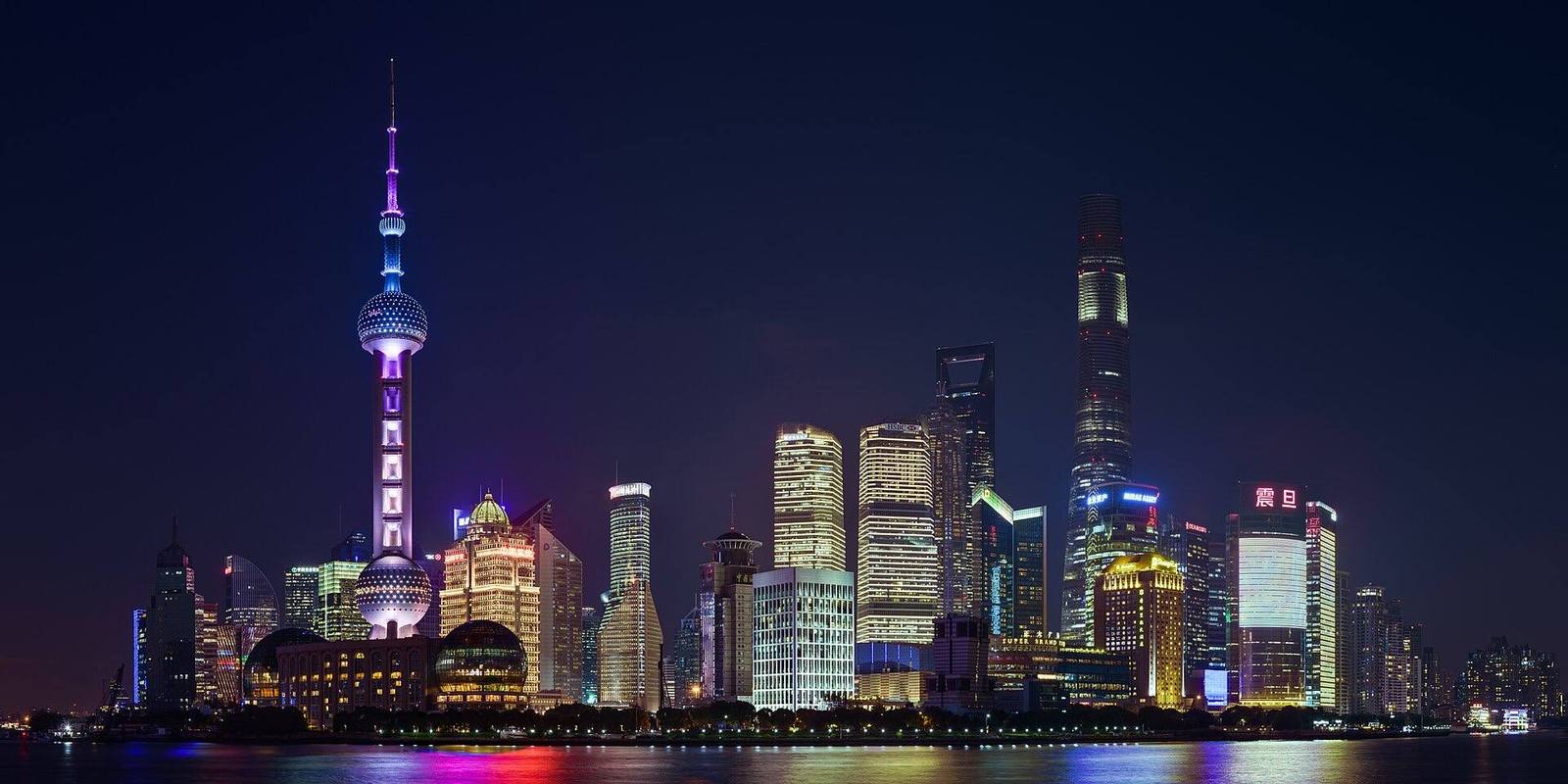 The Lujiazui skyline lit up at night across the Huangpu river